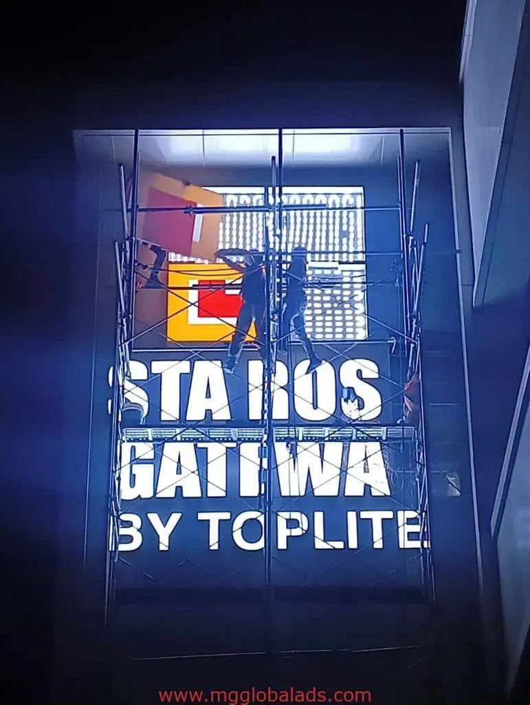 LED billboard installation for STARS GATEWAY BY TOPLITE in Makati at night, workers on scaffolding by M&G Global Ads.