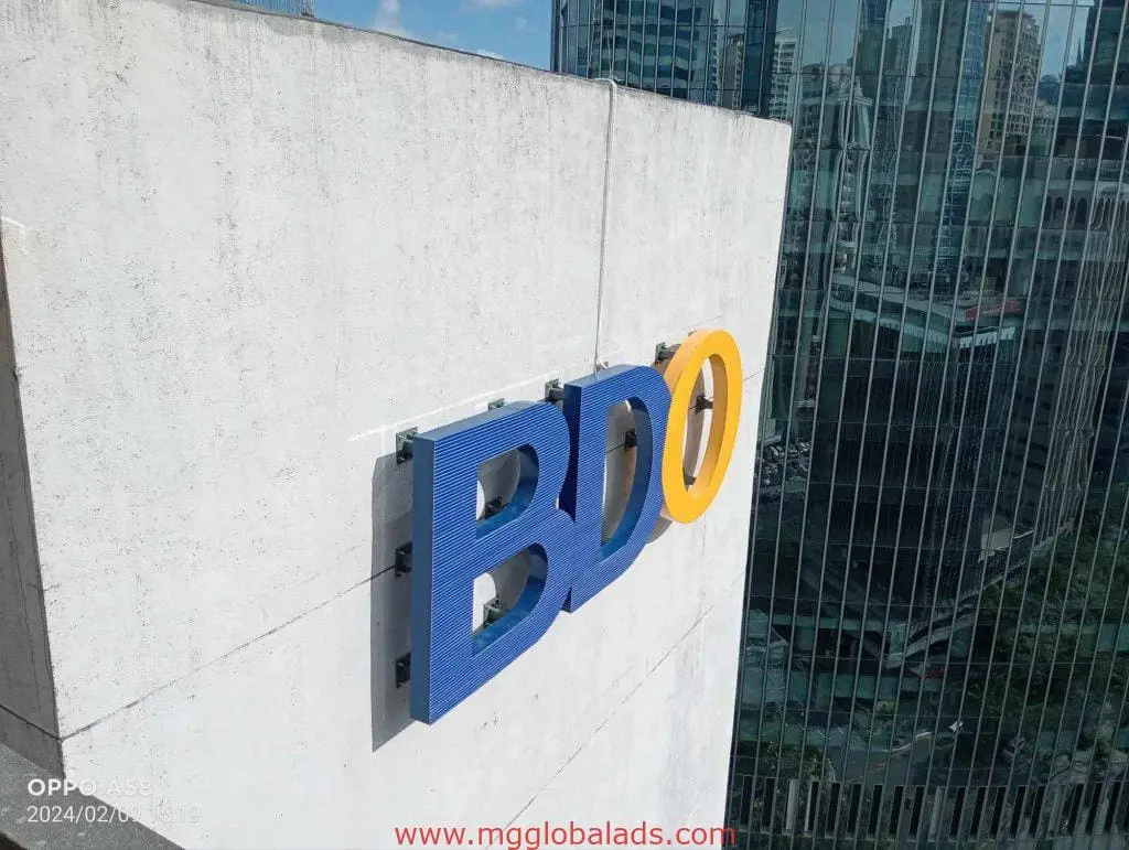 BDO building signage in blue and yellow, installed on a tall facade in Makati, by M&G Global Ads.