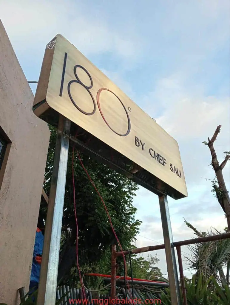 Outdoor metallic restaurant signage for 180° BY CHEF SAU in Makati, on metal poles with sky background by M&G Global Ads.
