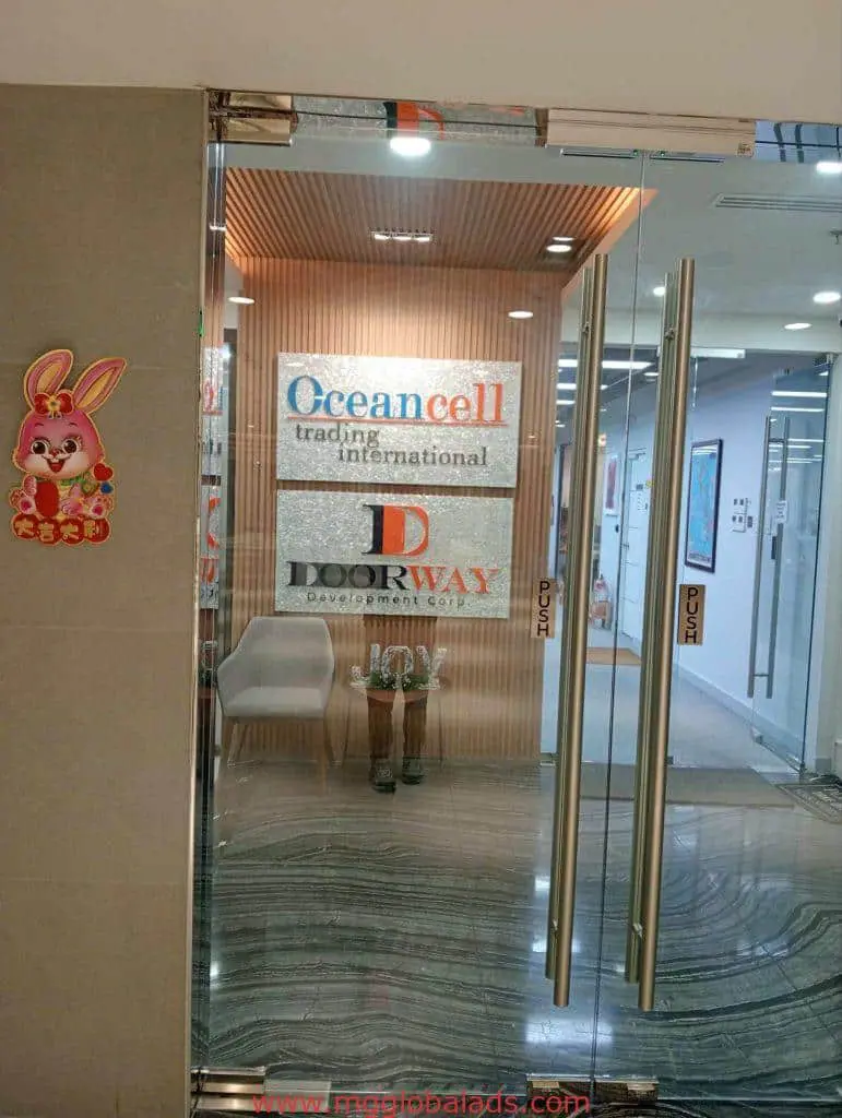 Metallic office logo signs for Oceancell Trading International and Doorway Development Corp in Makati lobby by M&G Global Ads.