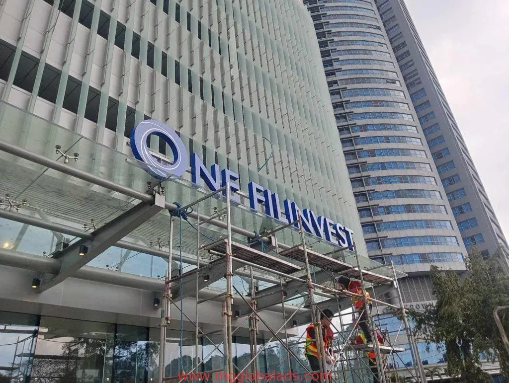 LED signage installation for ONE FILINVEST client in Makati, workers on scaffolding, modern glass building by M&G Global Ads.