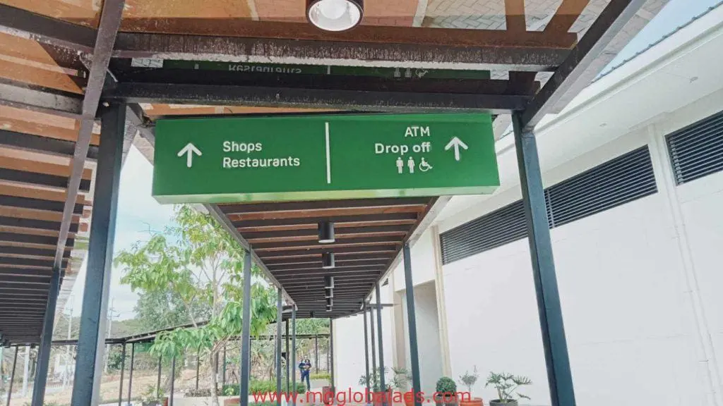 Green LED overhead wayfinding signage for shops, restaurants, ATM in Makati with accessibility icons by M&G Global Ads.
