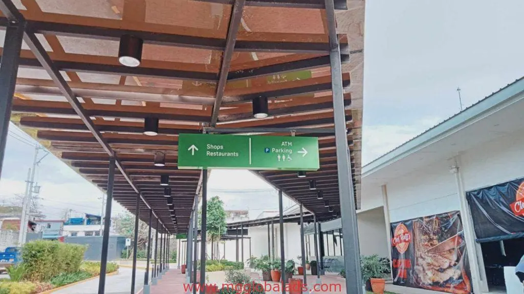 Green acrylic directional signage for shops, restaurants, ATM, parking in Quezon City mall walkway by M&G Global Ads.