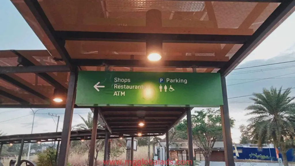 Overhead green acrylic directional signage in Makati for shops, restaurants, ATM, parking by M&G Global Ads.