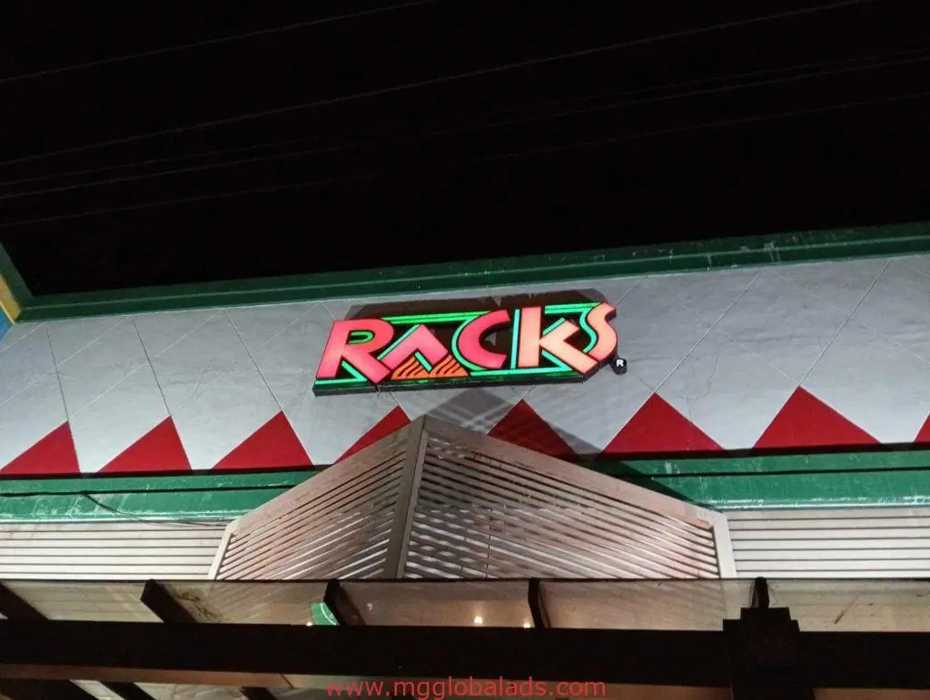 Illuminated LED signage for Racks restaurant in Makati with geometric green and red accents, exterior night view by M&G Global Ads.