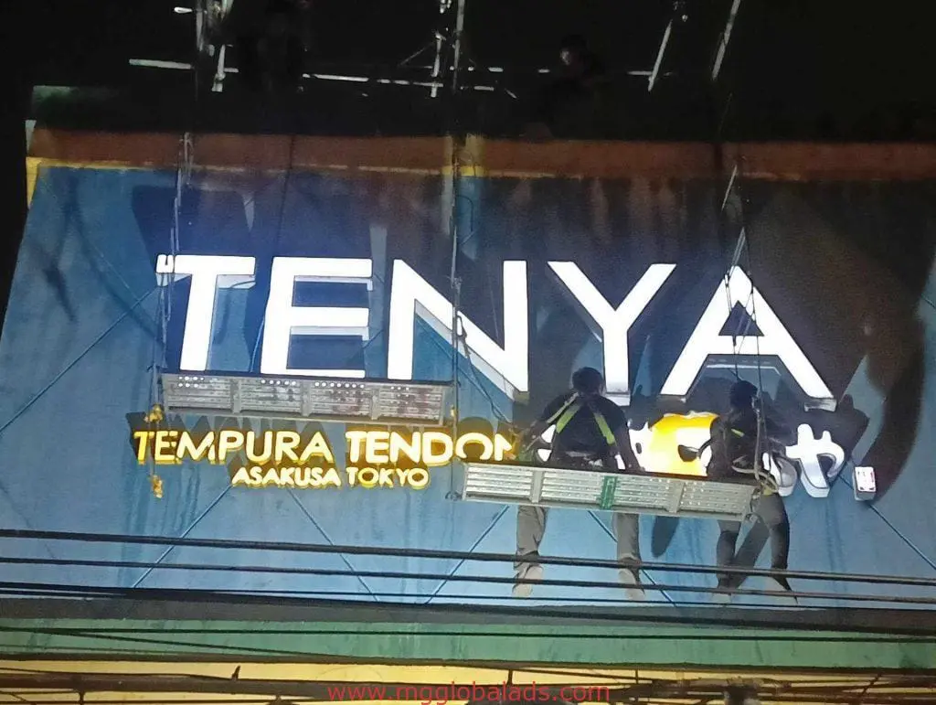 LED signage installation for Tenya Tempura Tendon in Makati by M&G Global Ads, workers on platform at night.