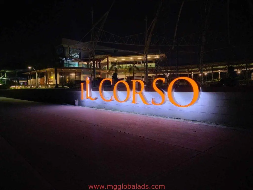 Illuminated acrylic IL CORSO outdoor signage in Makati with modern buildings at night, by M&G Global Ads.