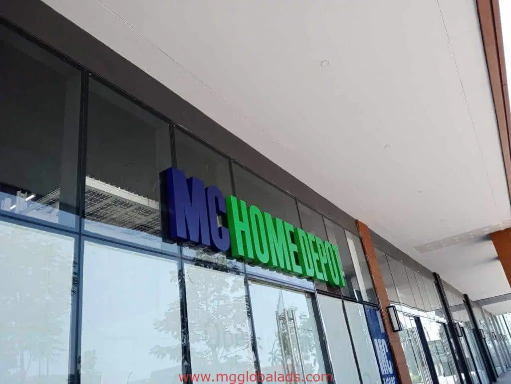 MC HOME DEPOT outdoor acrylic signage in blue and green at a glass storefront in Quezon City, by M&G Global Ads.