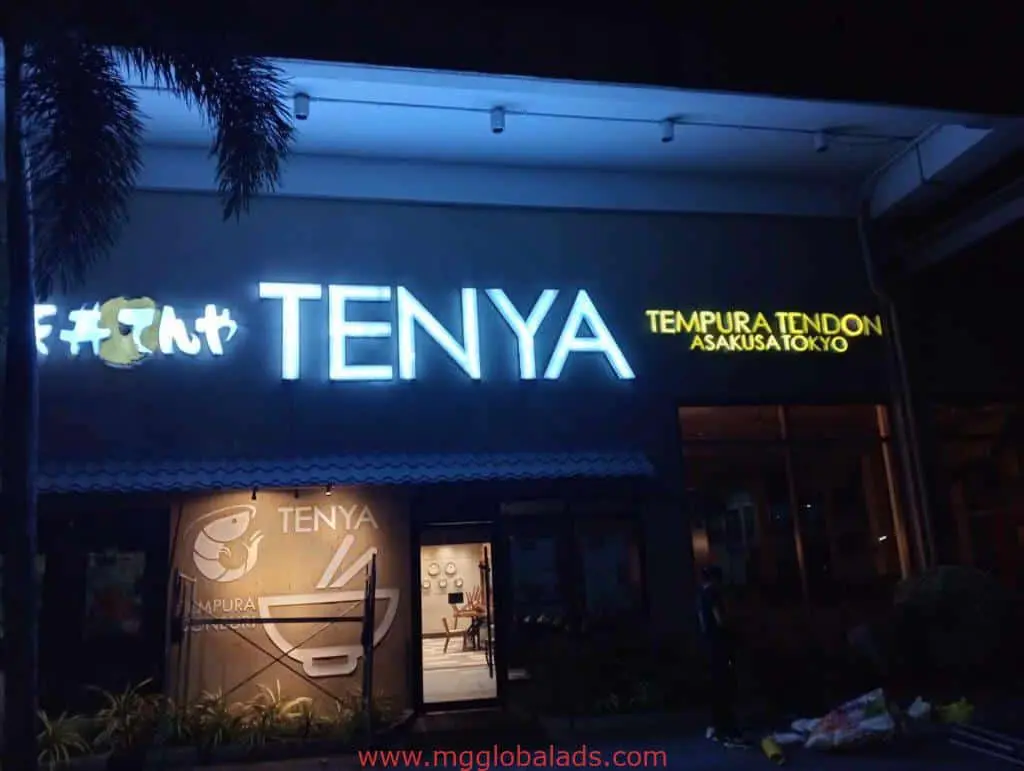 TENYA illuminated outdoor signage for restaurant in BGC at night, palm tree left of entrance, by M&G Global Ads.