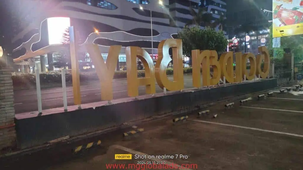 Illuminated outdoor signage with large golden BAY (reversed) letters in Makati, night scene, by M&G Global Ads.