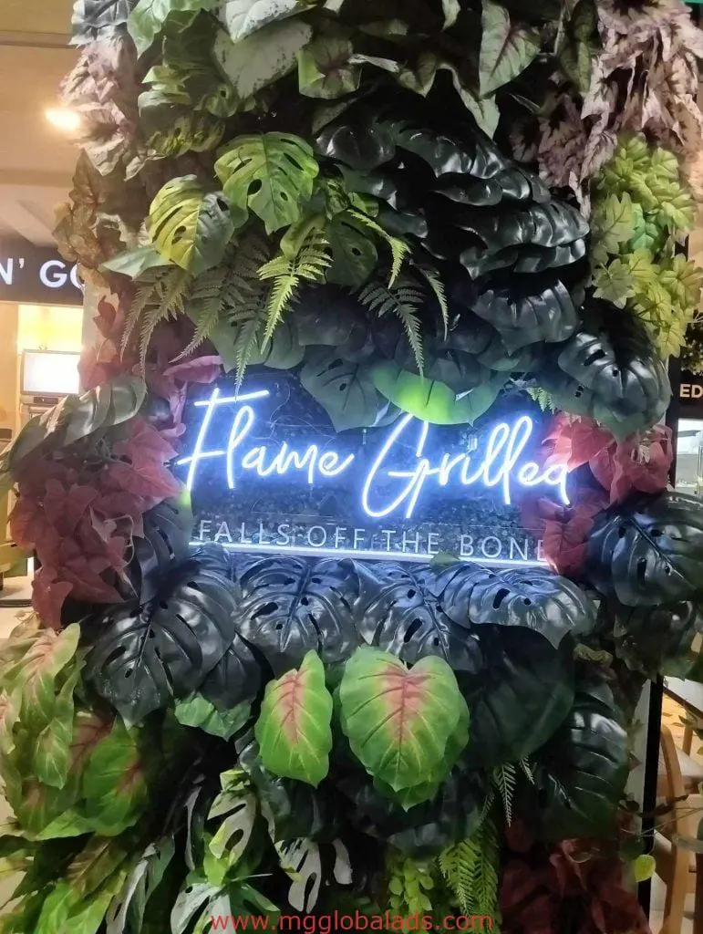 LED neon signage Flame Grilled, Falls Off the Bone with tropical leaves indoor display in BGC by M&G Global Ads.