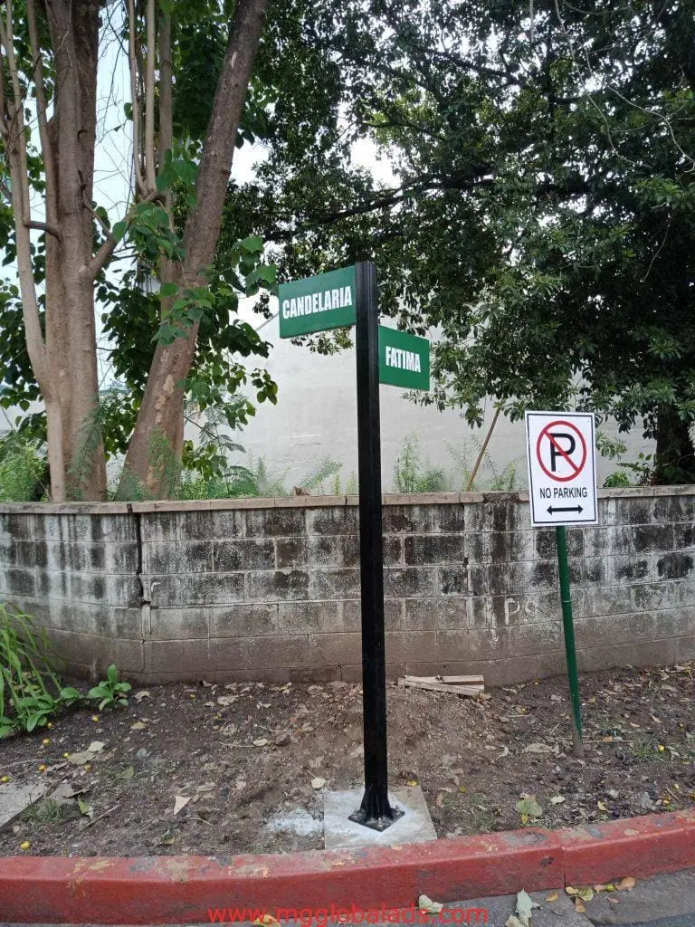 Street and No Parking signage, Candelaria & Fatima corner in Makati, trees, wall, leaves on ground by M&G Global Ads.