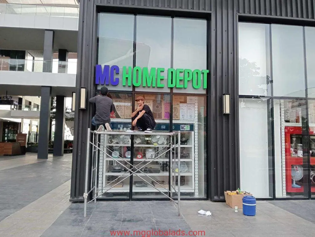 Outdoor LED signage installation for MC HOME DEPOT in Quezon City storefront, workers on scaffolding, by M&G Global Ads.