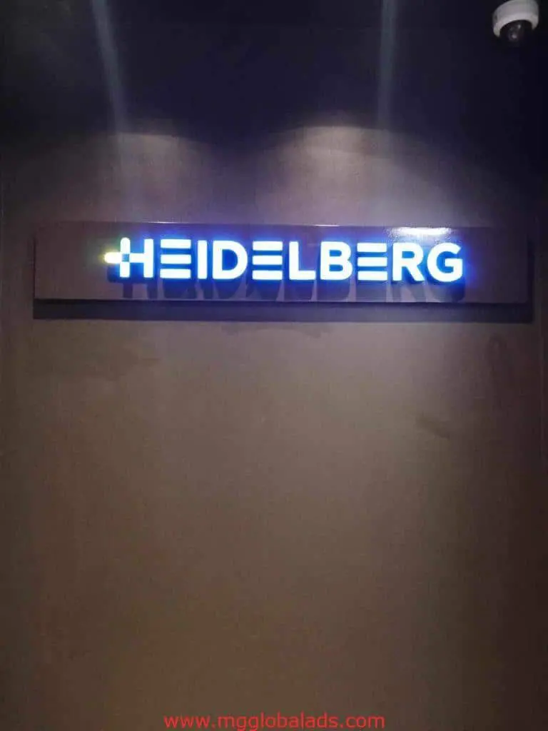 Outdoor LED signage for Heidelberg with blue-lit white uppercase letters on a dark wall in Makati by M&G Global Ads.
