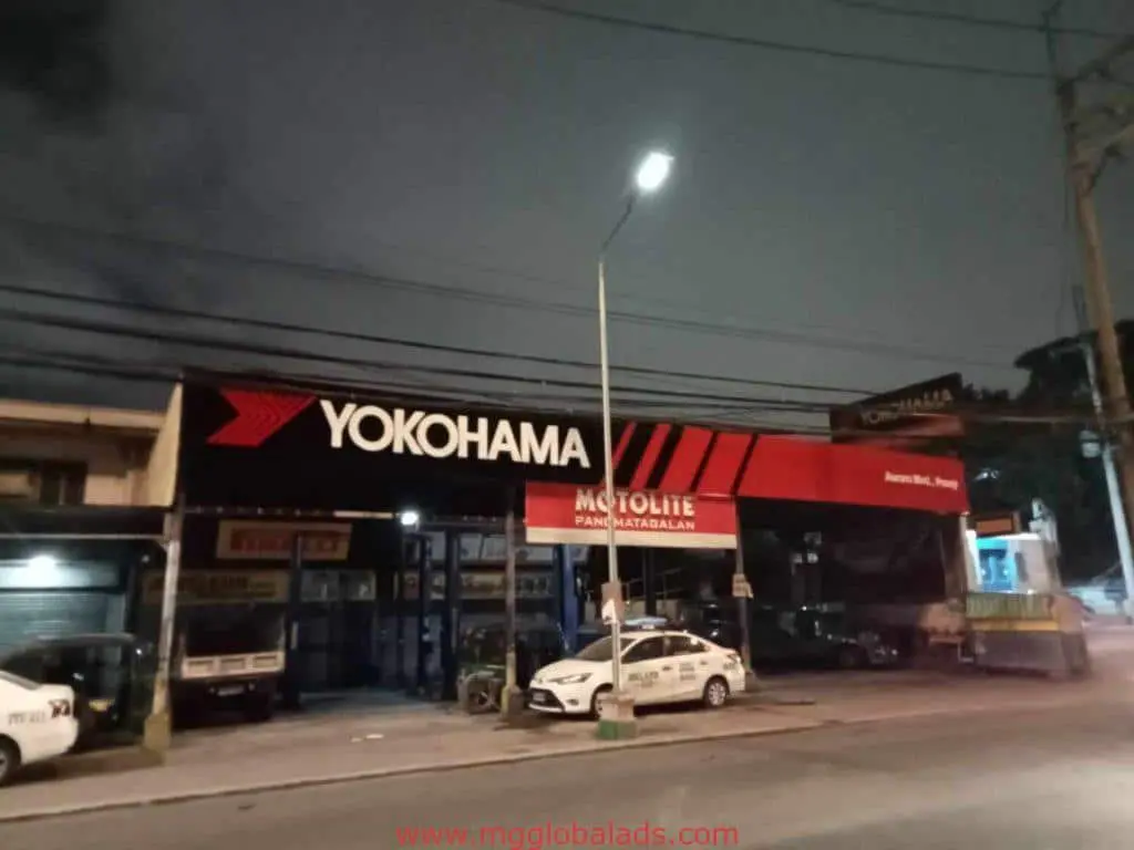 YOKOHAMA outdoor signage and MOTOLITE pylon sign at a tire shop in Quezon City at night by M&G Global Ads.
