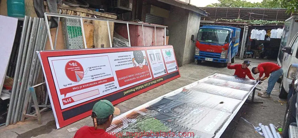 Outdoor building banner signage installation for business in Ortigas, workers assembling with tools by M&G Global Ads.