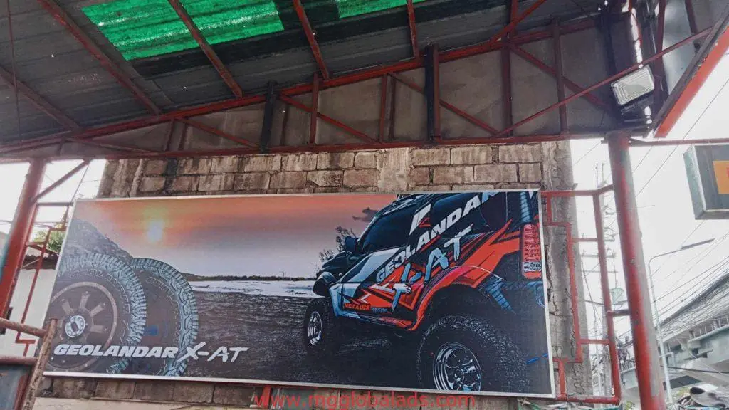 Billboard outdoor signage for Geolandar X-AT tires with rugged off-road vehicle in Makati, by M&G Global Ads.
