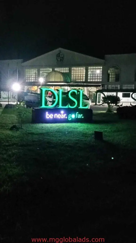 DLSL green and blue outdoor LED signage in front of arched building, Quezon City campus display by M&G Global Ads.
