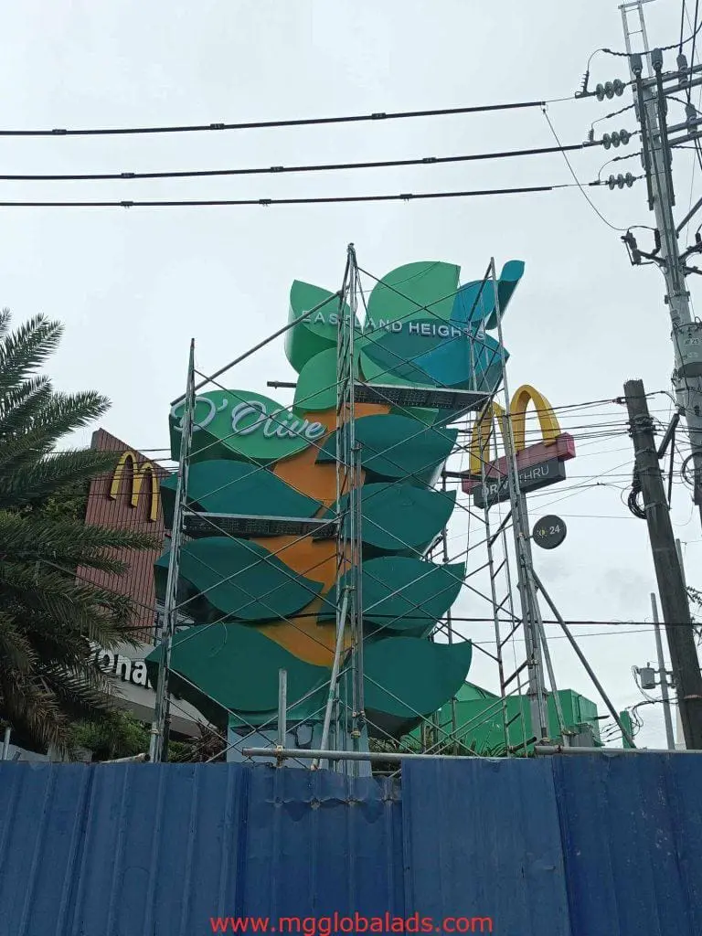 Outdoor billboard signage under construction with McDonalds logo in Mandaluyong, scaffolding and power lines by M&G Global Ads.