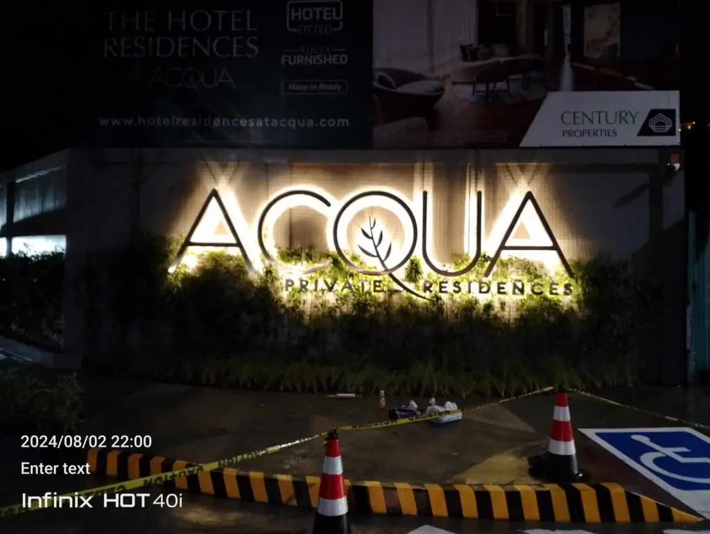 ACQUA Private Residences LED signage in Mandaluyong at night with cones, caution tape, hotel and billboard by M&G Global Ads.