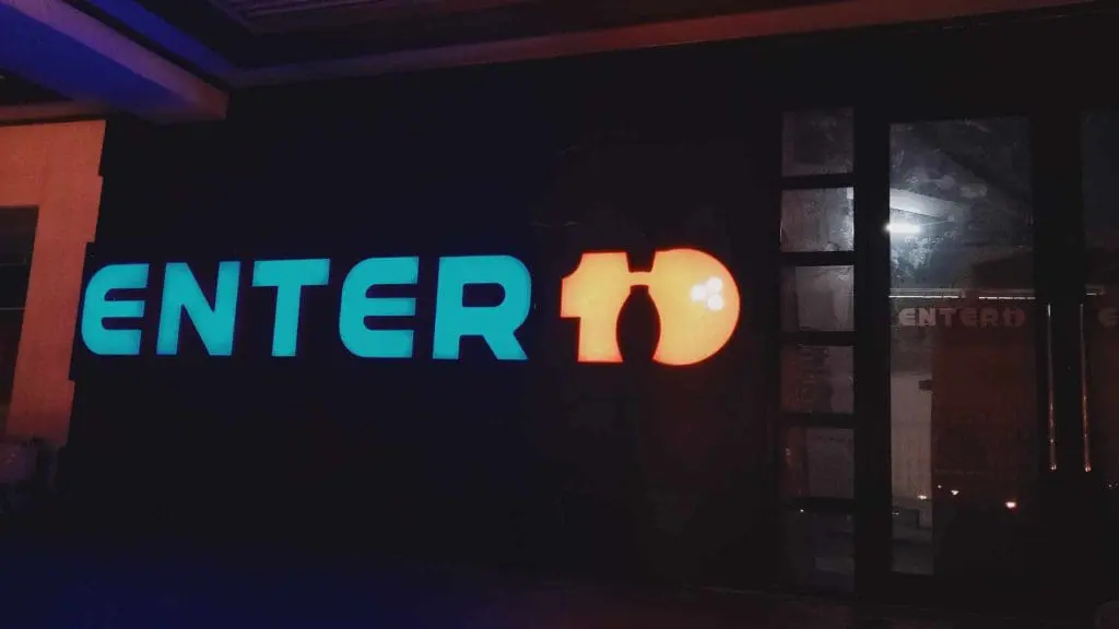 Acrylic building signage for ENTER10 in Makati, blue and orange with bottle-shaped 1, glass doors by M&G Global Ads.