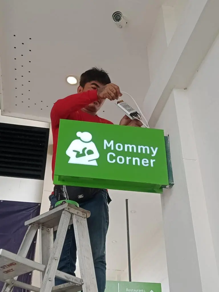 Mommy Corner indoor signage installation with parent-baby icon in Quezon City by M&G Global Ads.