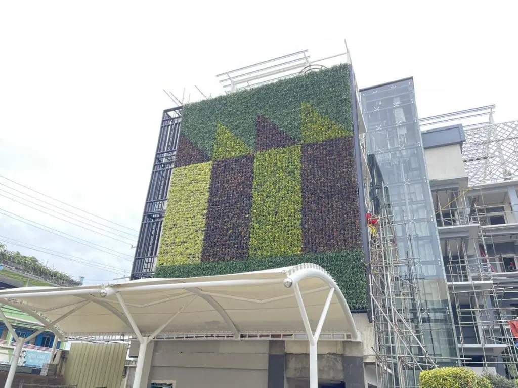 Vertical garden wall and metallic signage at commercial building in BGC with canopy and scaffolding by M&G Global Ads.