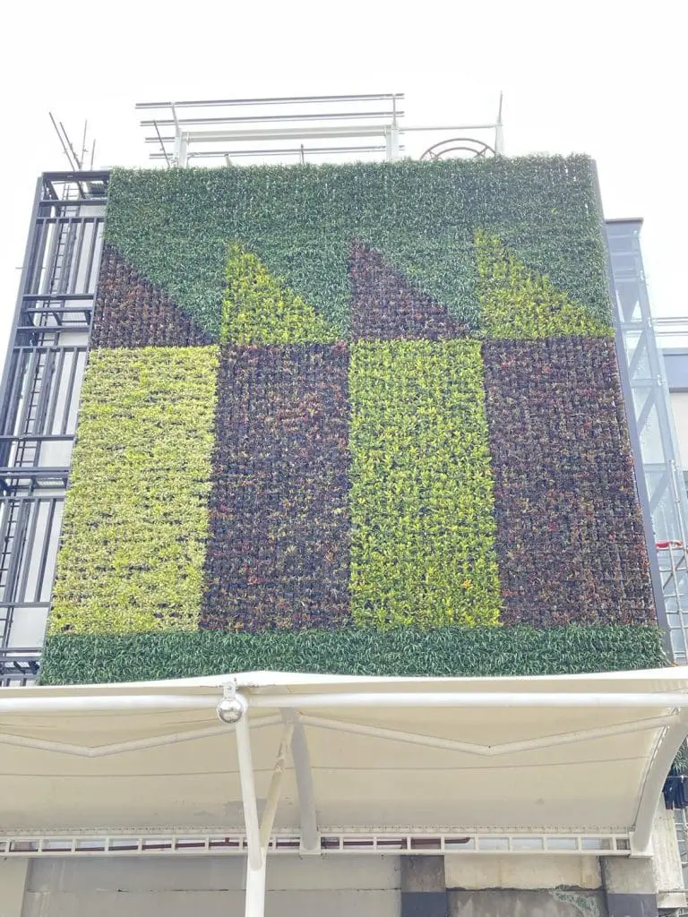 Vertical garden facade with geometric plant patterns and custom metal business signage in Makati, by M&G Global Ads.
