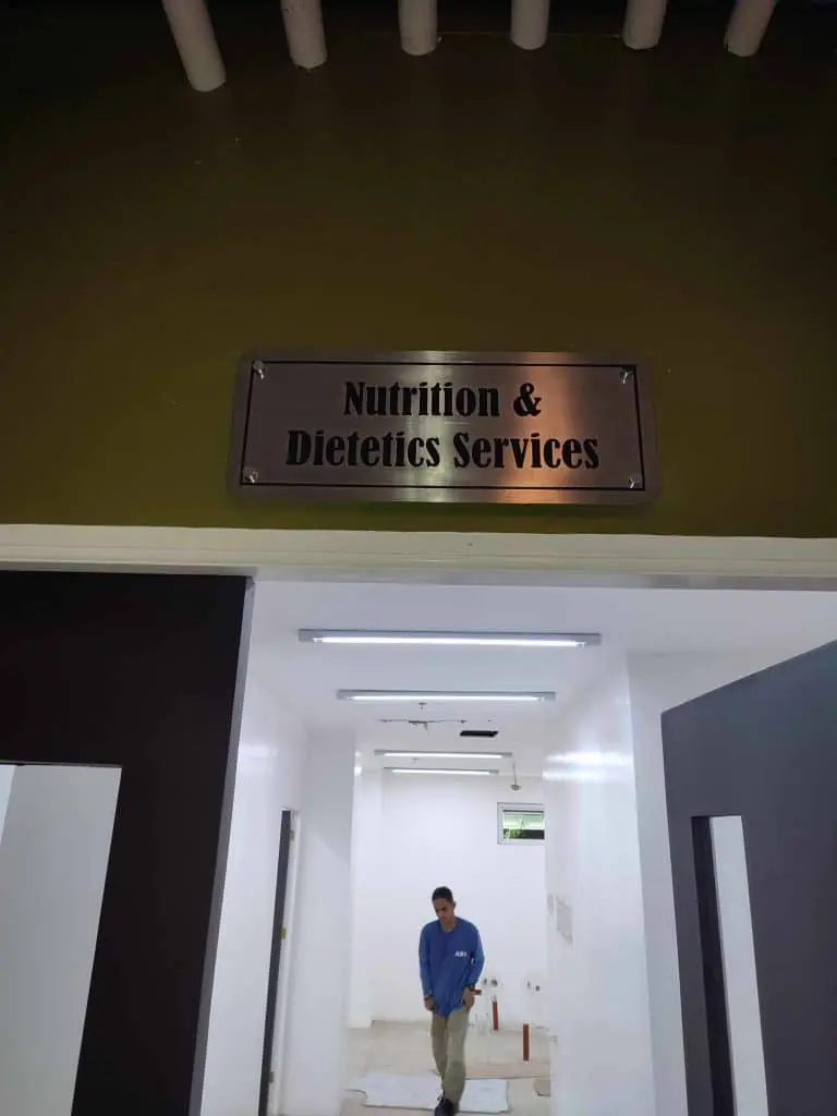 stainless engrave sign for Nutrition & Dietetics Services, hallway scene in Makati clinic setting by M&G Global Ads.