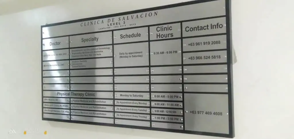 Metallic clinic signage for Clínica de Salvación in Makati displaying doctors, schedules, and services by M&G Global Ads.