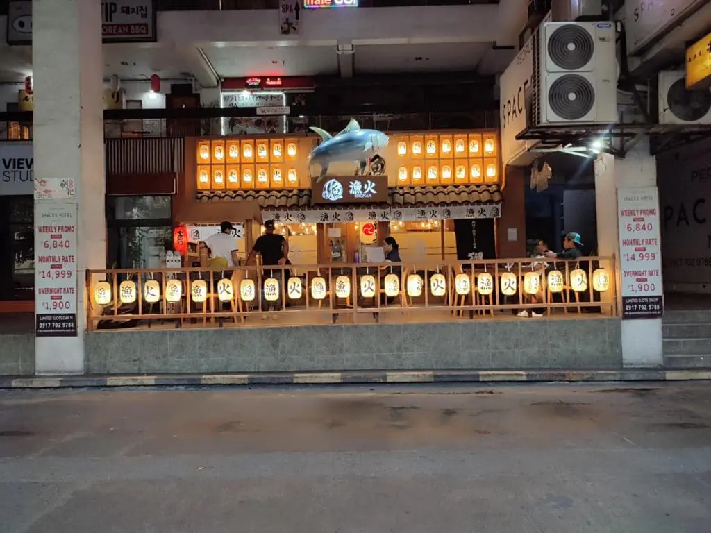 Japanese restaurant with LED signage, glowing lanterns, wooden decor in Makati, blue shark balloon at entrance by M&G Global Ads.