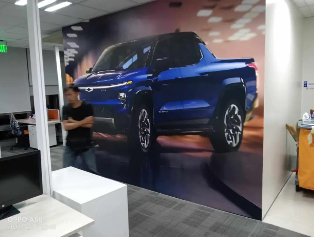 Wall mural of blue Chevrolet pickup truck and acrylic office signage at desks in Mandaluyong by M&G Global Ads.