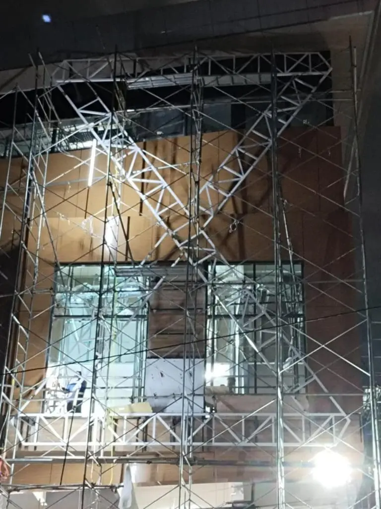 Construction site in Makati at night with scaffolding, windows, and billboard signage by M&G Global Ads.
