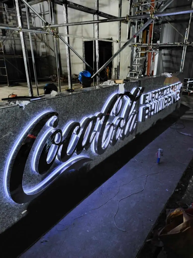 Coca-Cola European Partners LED signage at construction site in Makati, surrounded by scaffolding and materials by M&G Global Ads.