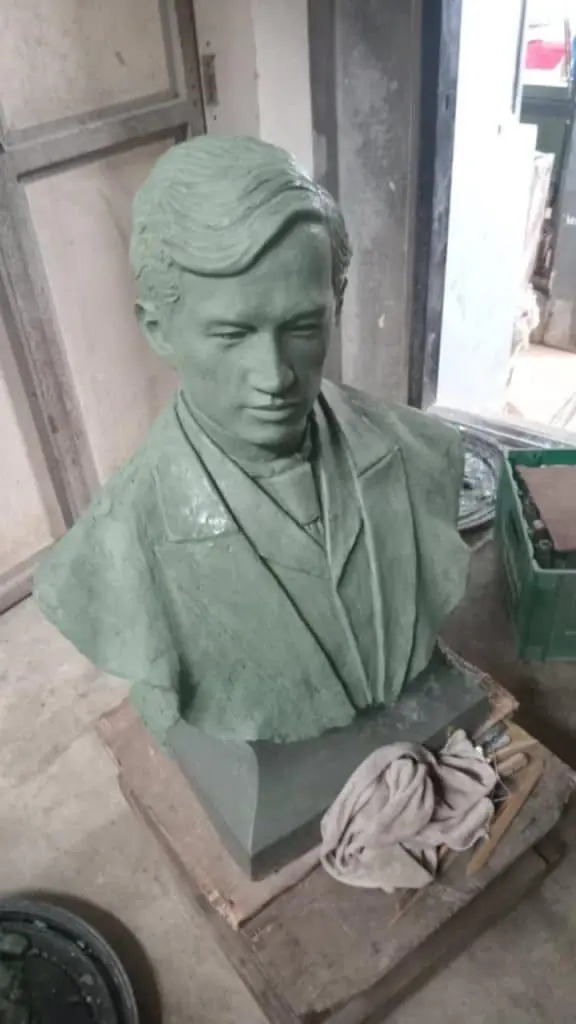 Building signage materials with green bust sculpture in suit and tie, workshop setting in Quezon City by M&G Global Ads.