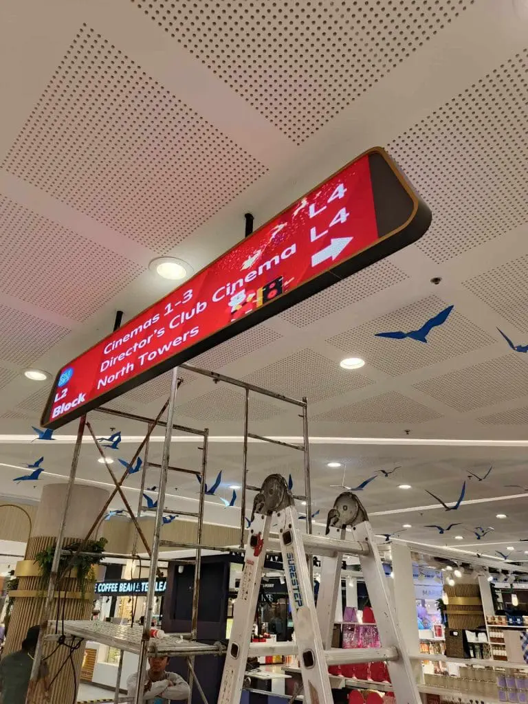 Digital wayfinding ceiling signage for cinemas and directors club in Makati, with ladders, scaffolding by M&G Global Ads.