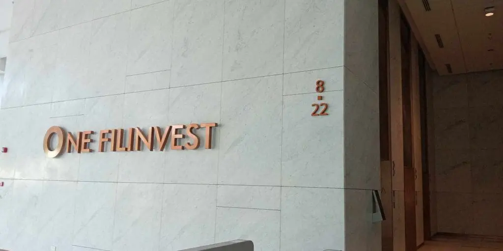 Metallic office signage for ONE FILINVEST with copper letters in Makati, marble wall background. By M&G Global Ads.