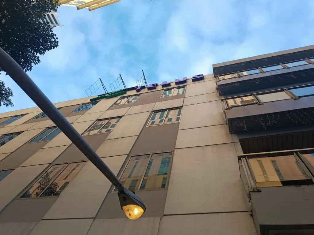 LED rooftop signage on multi-story building in Makati, blue sky background, streetlight lit daytime by M&G Global Ads.