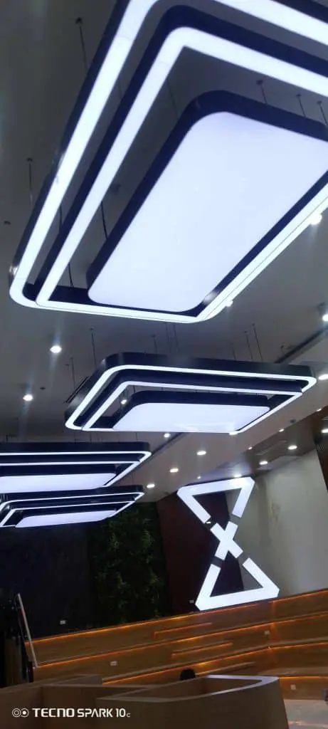 Rectangular geometric LED signage ceiling lights in modern interior, wood steps, abstract wall in Makati by M&G Global Ads.