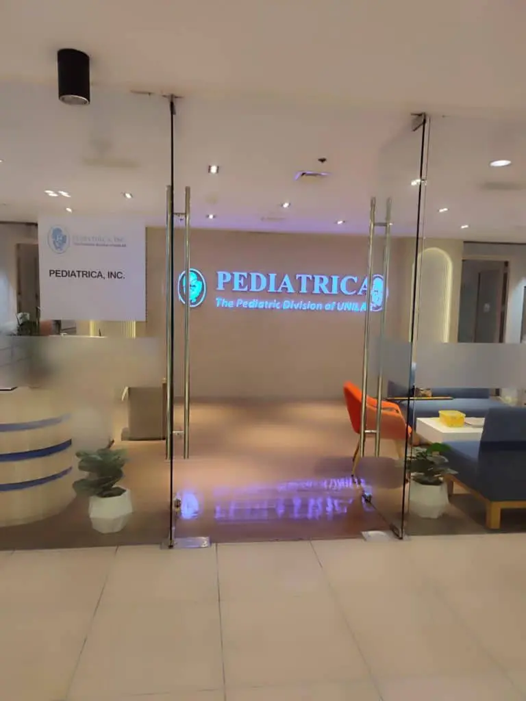 Illuminated PEDIATRICA clinic signage for UNI in Makati, glass entrance, reception desk, modern seating by M&G Global Ads.