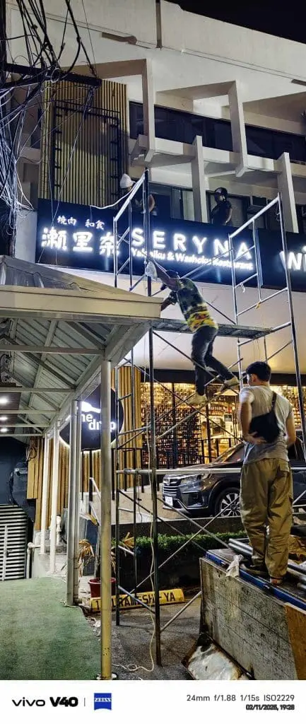 LED billboard installation for commercial client in Makati, workers on scaffolding at night, by M&G Global Ads.