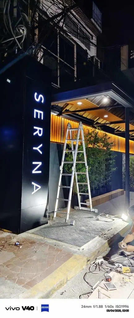 LED restaurant signage for SERYNA in Makati, shown at night with ladder and plants by entrance. By M&G Global Ads.