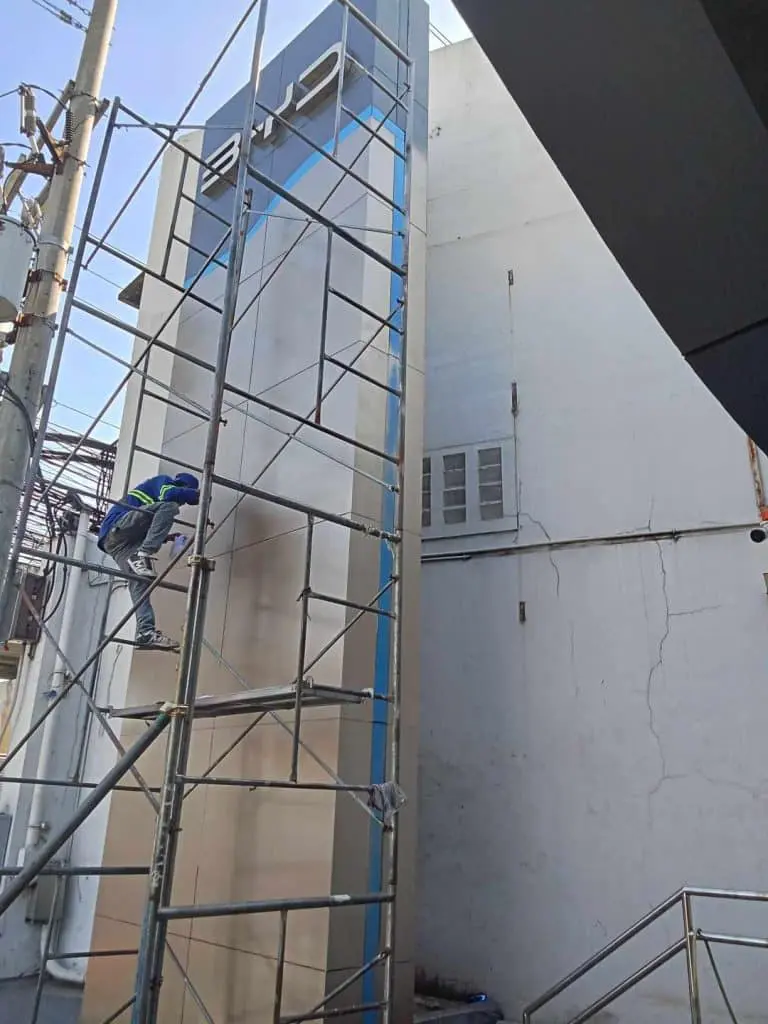 LED billboard outdoor signage installation in Makati with worker on scaffolding by M&G Global Ads.