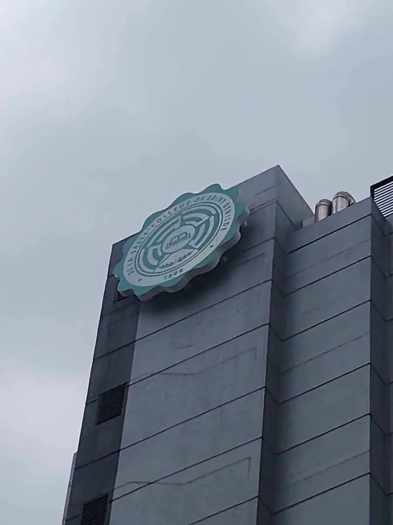 Acrylic rooftop signage for Nigerian Institute of Journalism on gray building, cloudy sky, Makati. Installed by M&G Global Ads.