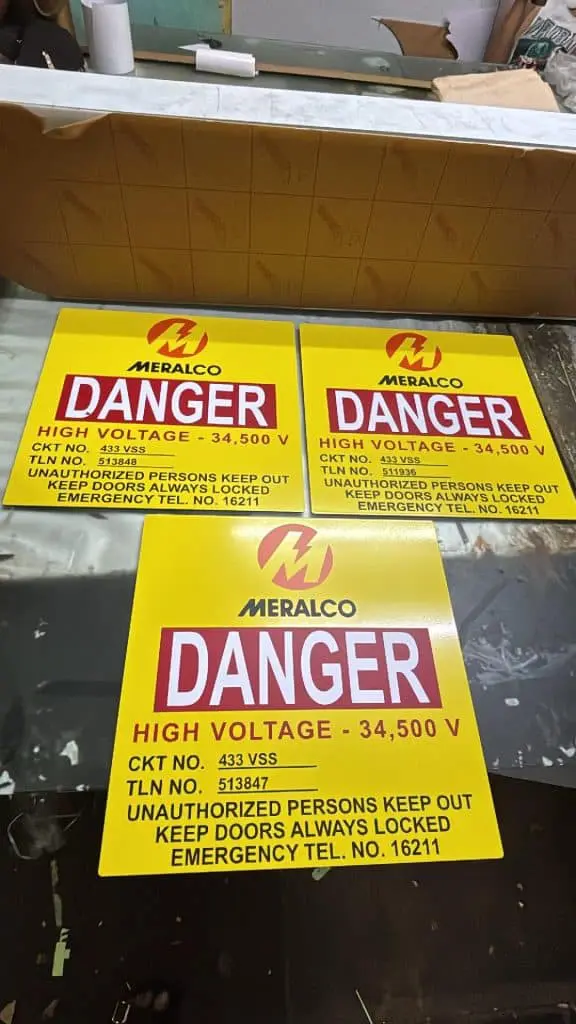 Meralco high voltage metallic safety signs outdoor signage in Quezon City, warnings and emergency number, by M&G Global Ads.