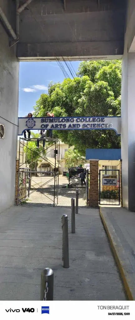 Sumulong College entrance metallic signage in Pasig, campus buildings and trees visible by M&G Global Ads.