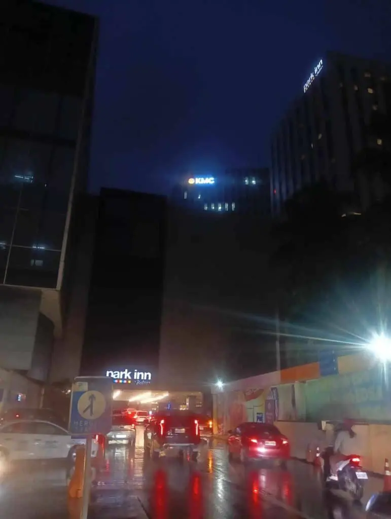 LED building signage for KMAC and Park Inn hotels in Makati, nighttime wet street scene with street signs by M&G Global Ads.