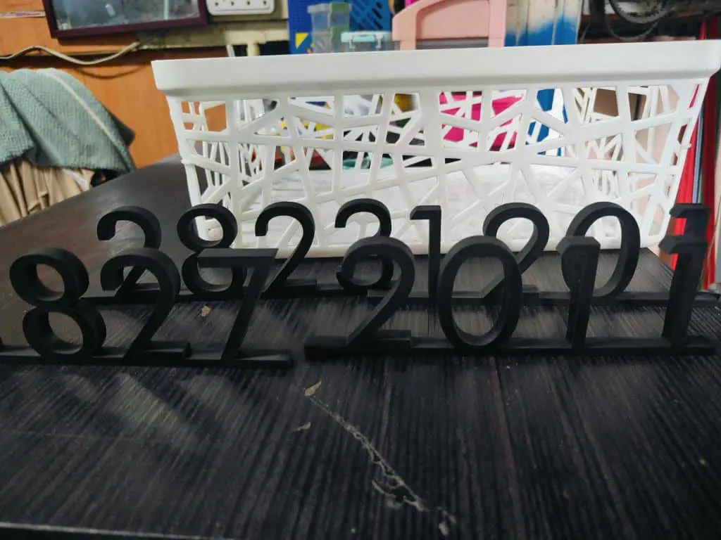 3D-printed black indoor signage numbers 8222011 for offices in Mandaluyong, shown on a table, by M&G Global Ads.