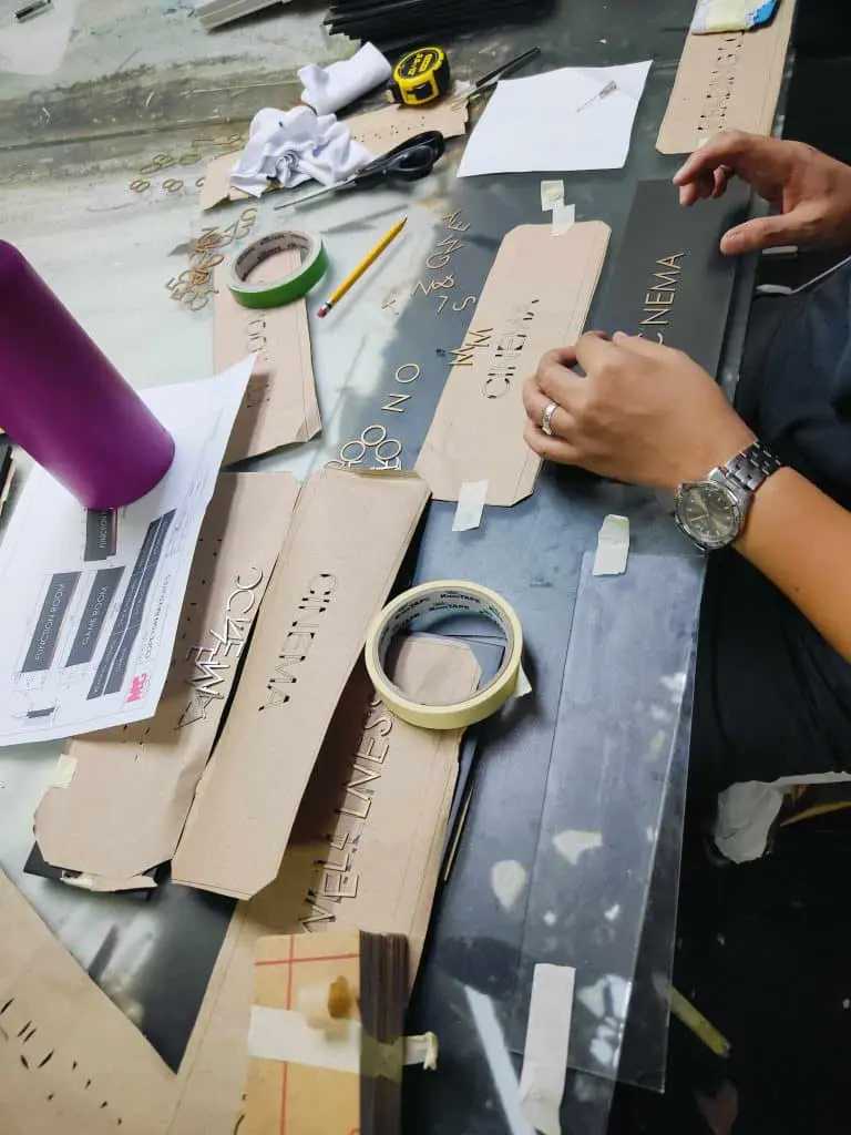 Custom acrylic signage making workspace in Ortigas with stencils, templates, and tools—arranged by M&G Global Ads.