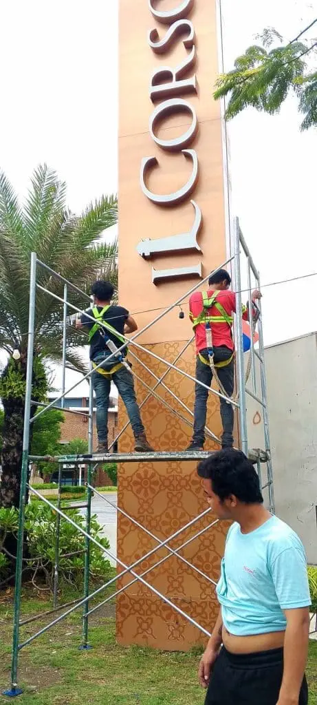Outdoor pylon signage installation for IL CORSO by workers on scaffolding in Quezon City, by M&G Global Ads.